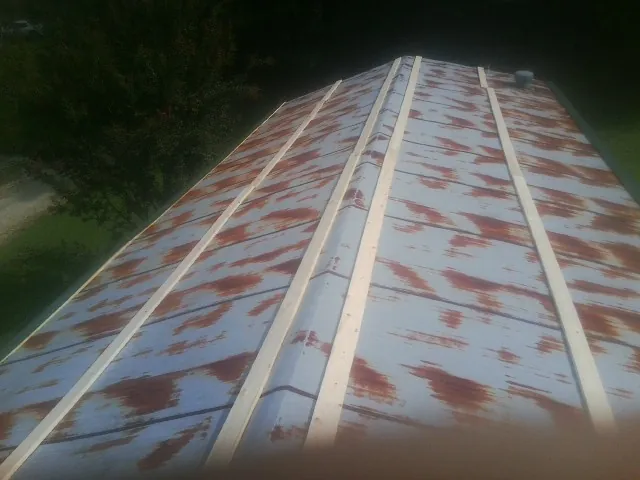 Rusted metal roof panels with new wood purlins before replacement — Storm Damage Roof Repair in Ray City by Roofing Brothers