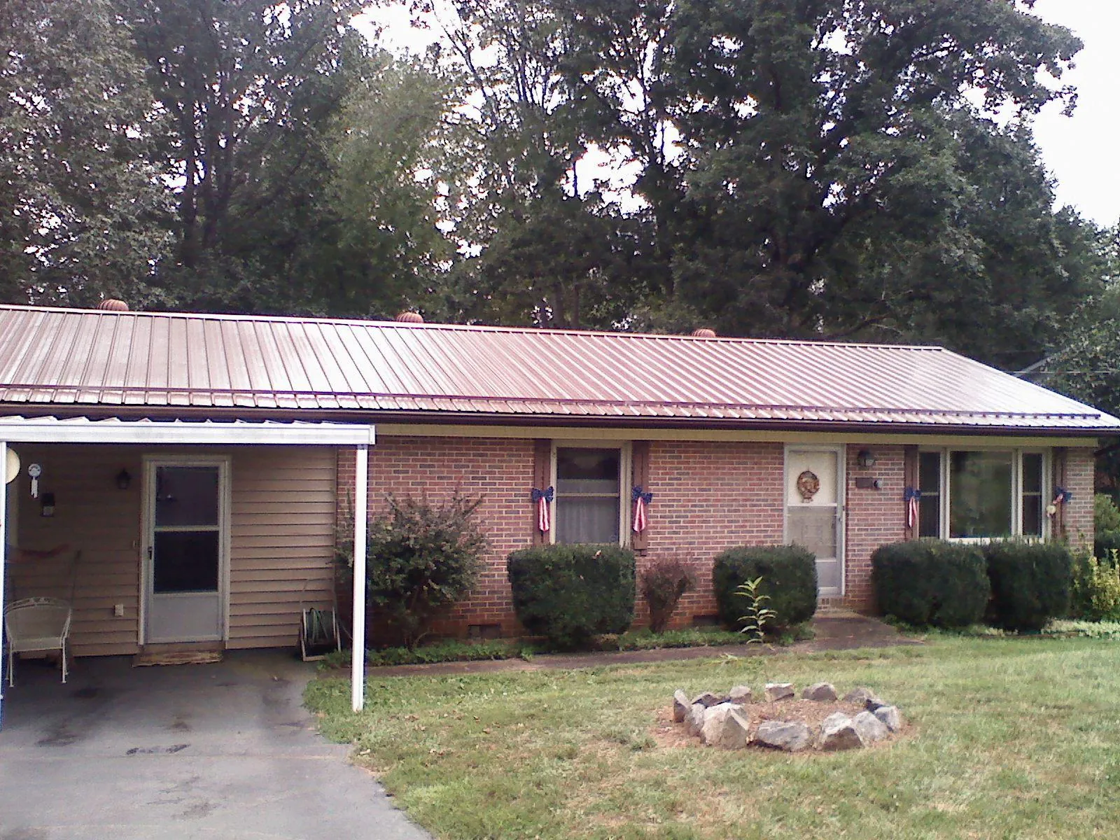 Bronze metal roof and carport on a brick ranch home — Roof Repair work by our crew in Ray City